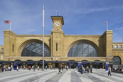 The yellow-brick facade and clock tower of King's Cross station